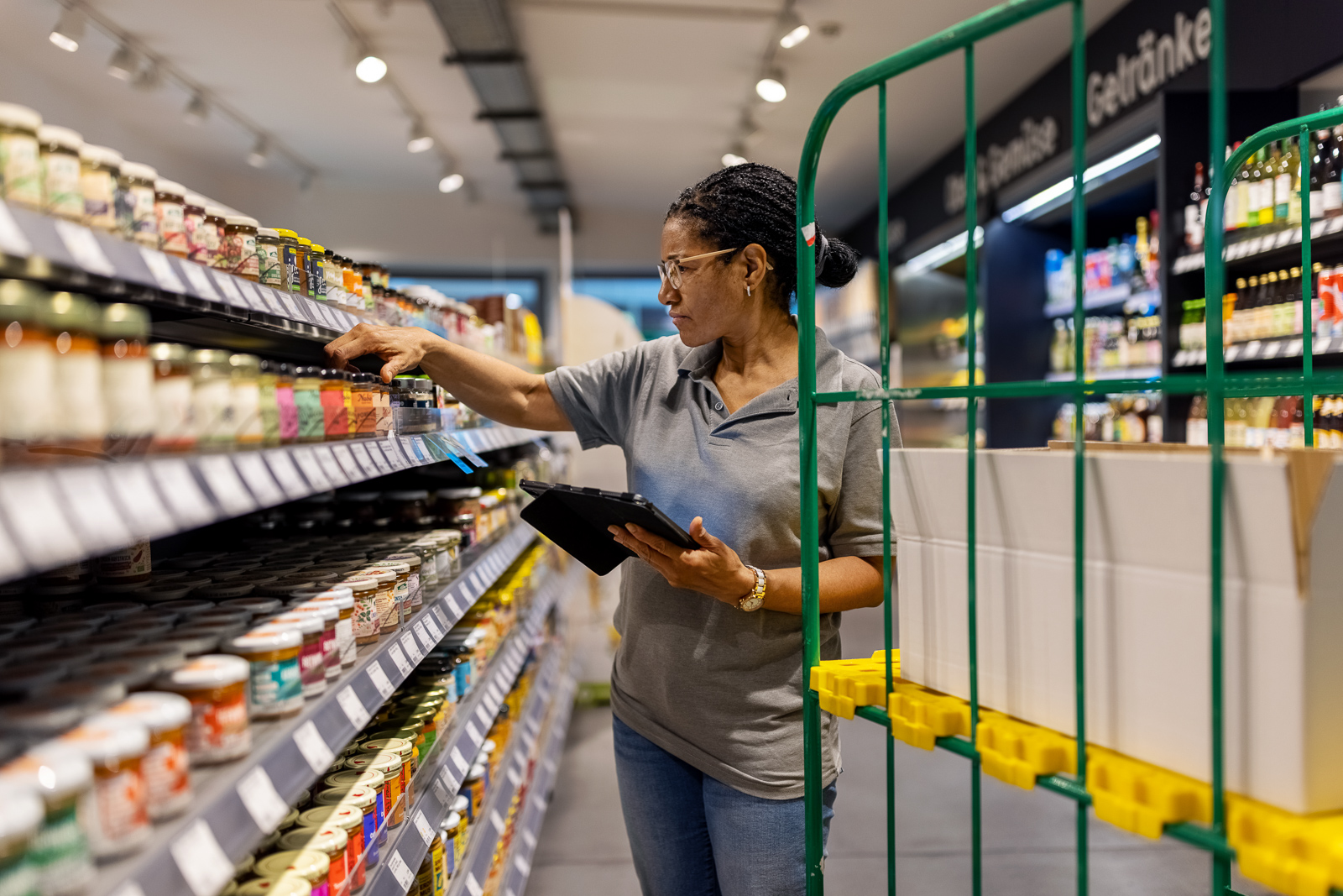 Woman checking items on a shelf in a grocery store