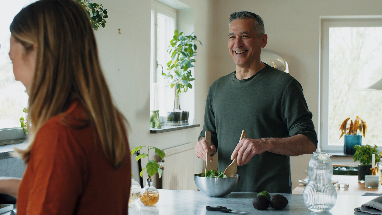 Laughing man mixing salad